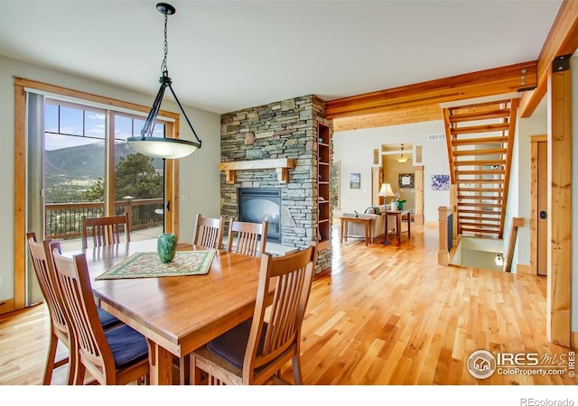 303 Curry Dr, Estes Park, CO 80517 - dining room with light wood finished floors, a stone fireplace, and stairs