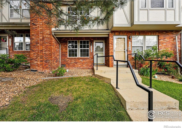 3022 W 107th Pl Unit D, Westminster, CO 80031 - view of exterior entry with brick siding and a lawn