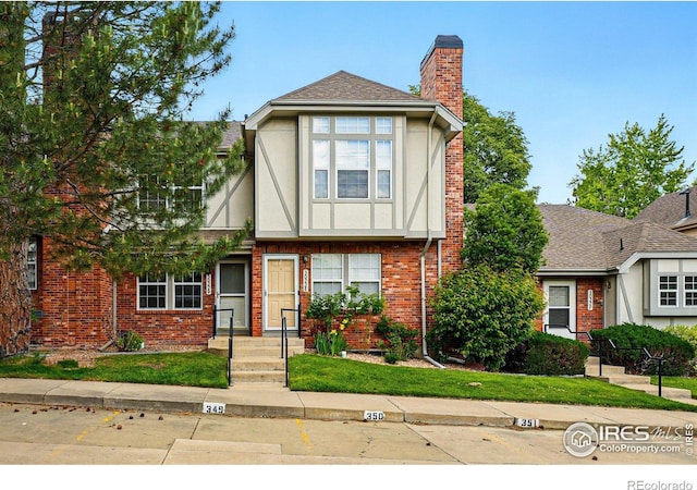 3022 W 107th Pl Unit D, Westminster, CO 80031 - tudor house featuring a chimney, stucco siding, and brick siding
