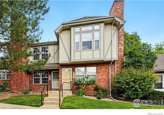 3022 W 107th Pl Unit D, Westminster, CO 80031 - tudor-style house with a chimney, stucco siding, and brick siding