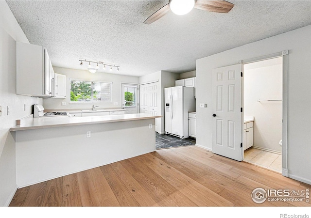 3022 W 107th Pl Unit D, Westminster, CO 80031 - kitchen with white appliances, a sink, a peninsula, light wood-style flooring, and ceiling fan