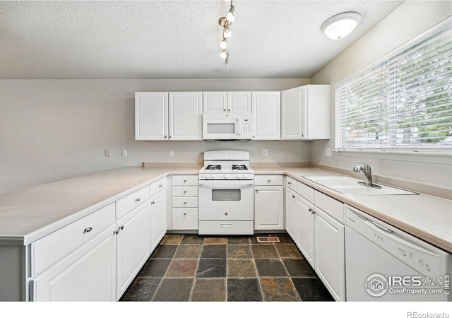 3022 W 107th Pl Unit D, Westminster, CO 80031 - kitchen featuring white appliances, a sink, white cabinetry, a textured ceiling, and dark stone finish floors