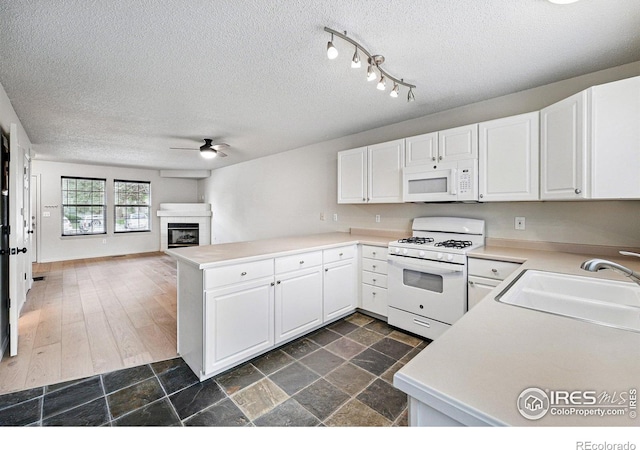 3022 W 107th Pl Unit D, Westminster, CO 80031 - kitchen with white appliances, a sink, a peninsula, a ceiling fan, and white cabinetry