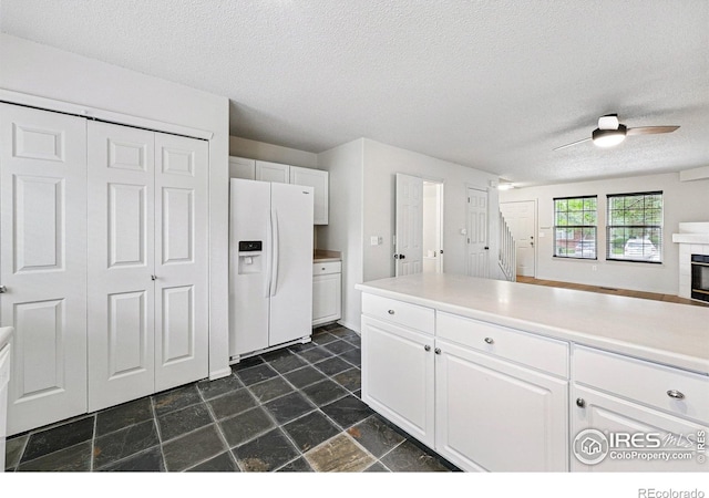 3022 W 107th Pl Unit D, Westminster, CO 80031 - kitchen with white fridge with ice dispenser, a textured ceiling, white cabinetry, open floor plan, and ceiling fan