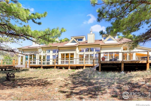 125 Saddleback Ln, Estes Park, CO 80517 - rear view of house with a chimney and a wooden deck