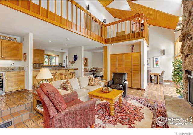125 Saddleback Ln, Estes Park, CO 80517 - living area featuring light tile patterned floors, wine cooler, a high ceiling, recessed lighting, and a fireplace