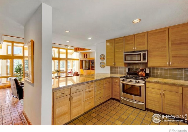 125 Saddleback Ln, Estes Park, CO 80517 - kitchen featuring stainless steel appliances, tile patterned flooring, tasteful backsplash, a peninsula, and recessed lighting