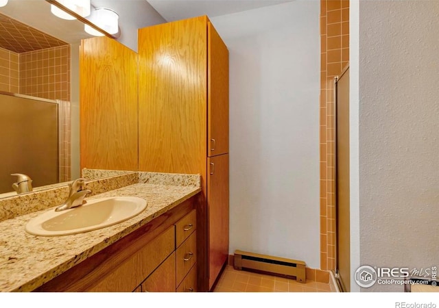 125 Saddleback Ln, Estes Park, CO 80517 - full bathroom featuring baseboard heating, a stall shower, vanity, and tile patterned flooring
