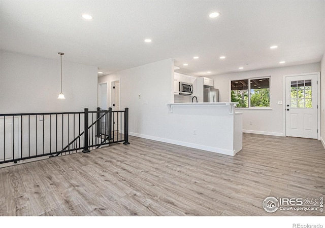 15904 E Bates Pl, Aurora, CO 80013 - kitchen featuring stainless steel appliances, recessed lighting, light wood finished floors, white cabinets, and baseboards