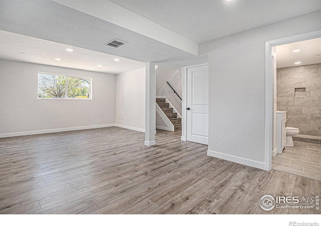 15904 E Bates Pl, Aurora, CO 80013 - below grade area featuring stairway, wood finished floors, baseboards, and recessed lighting