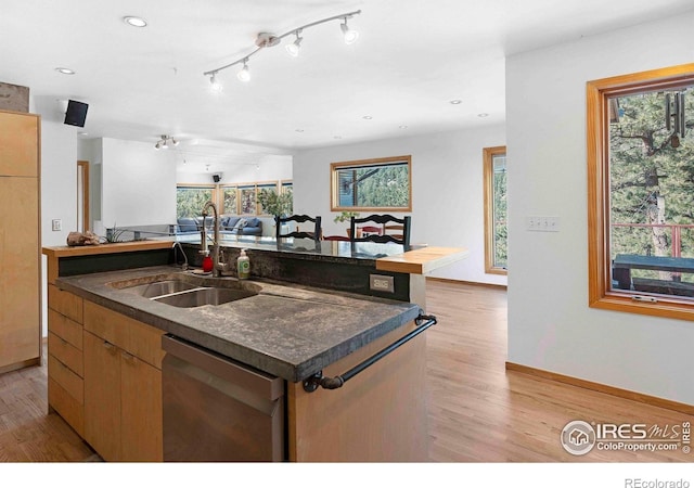 398 Fred Rd, Boulder, CO 80302 - kitchen with dishwasher, open floor plan, dark countertops, a center island with sink, and a sink