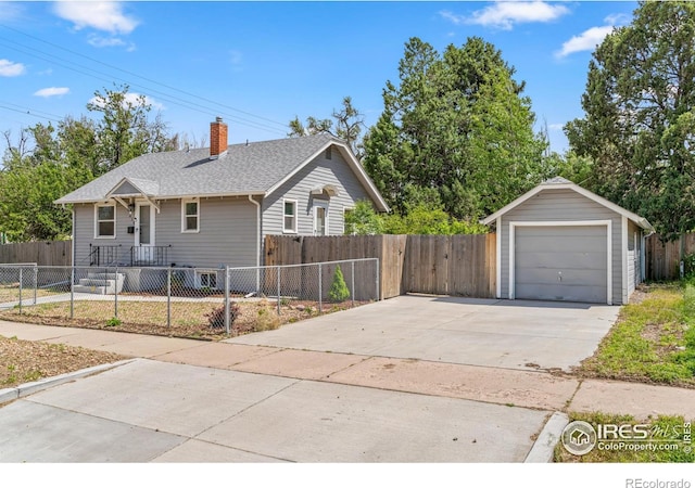 618 16th St, Greeley, CO 80631 - view of front facade featuring a chimney, a fenced front yard, a detached garage, concrete driveway, and an outbuilding