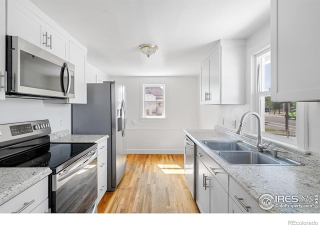 618 16th St, Greeley, CO 80631 - kitchen with appliances with stainless steel finishes, a sink, light wood-style floors, and white cabinets