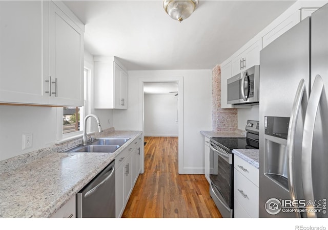 618 16th St, Greeley, CO 80631 - kitchen featuring stainless steel appliances, a sink, white cabinetry, and light wood finished floors
