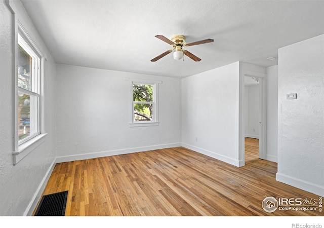 618 16th St, Greeley, CO 80631 - spare room featuring light wood-style floors, a ceiling fan, baseboards, and a textured wall