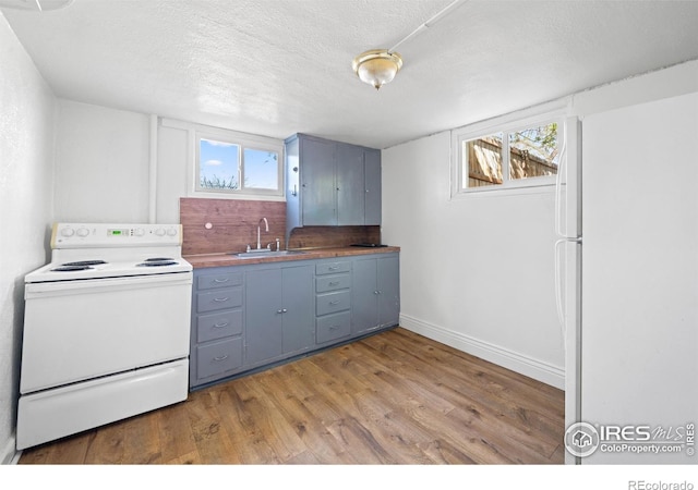 618 16th St, Greeley, CO 80631 - kitchen with white appliances, a sink, light wood-style flooring, gray cabinetry, and blue cabinets
