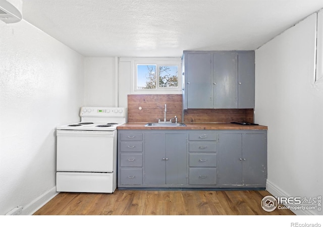 618 16th St, Greeley, CO 80631 - kitchen featuring white electric range oven, gray cabinetry, a sink, wood finished floors, and baseboards