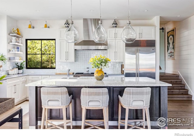 3737 Spring Valley Rd, Boulder, CO 80304 - kitchen with stainless steel built in refrigerator, wall chimney exhaust hood, wood finished floors, a sink, and white cabinetry