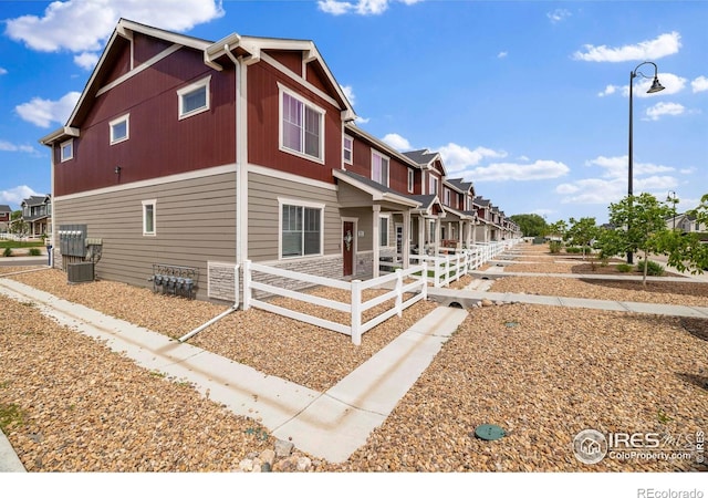 253 Molinar St, Johnstown, CO 80534 - view of home's exterior featuring a fenced front yard, central AC, and a residential view