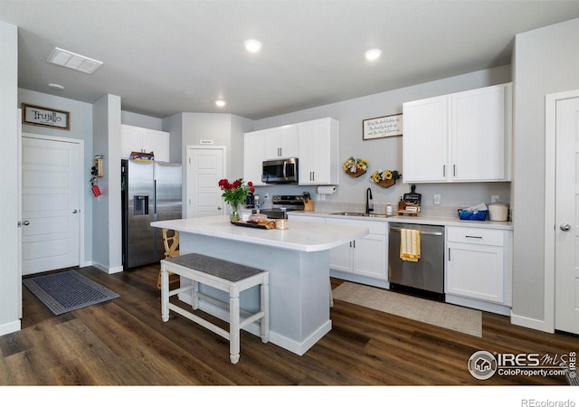 253 Molinar St, Johnstown, CO 80534 - kitchen featuring stainless steel appliances, a kitchen breakfast bar, dark wood-type flooring, a sink, and white cabinets