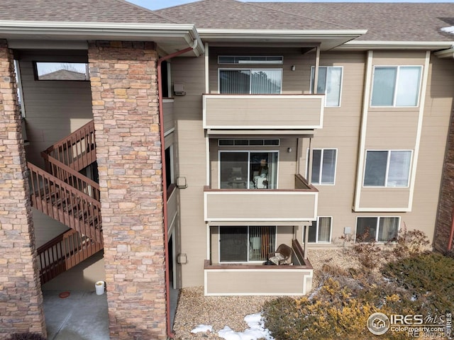 4545 Wheaton Dr Unit A-290, Fort Collins, CO 80525 - rear view of property featuring a shingled roof and stairs