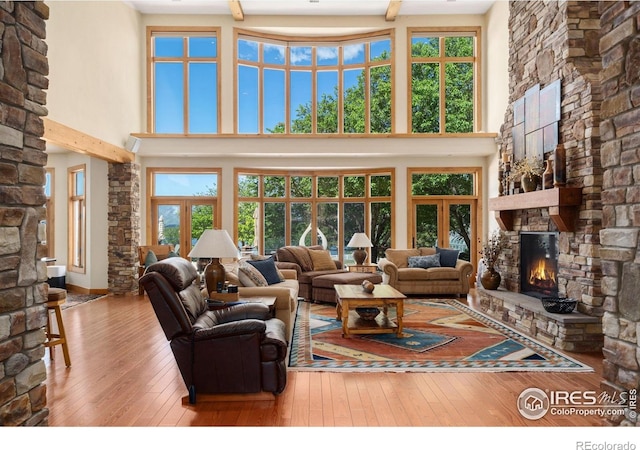 5025 Eagle Lake Dr, Fort Collins, CO 80524 - living area with a fireplace, a towering ceiling, wood-type flooring, and french doors