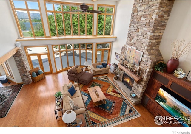 5025 Eagle Lake Dr, Fort Collins, CO 80524 - living room featuring a fireplace, a towering ceiling, wood finished floors, and ceiling fan