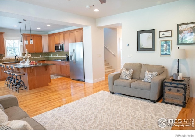 6523 Spanish Bay Dr, Windsor, CO 80550 - living area featuring light wood finished floors, stairs, ceiling fan, recessed lighting, and baseboards