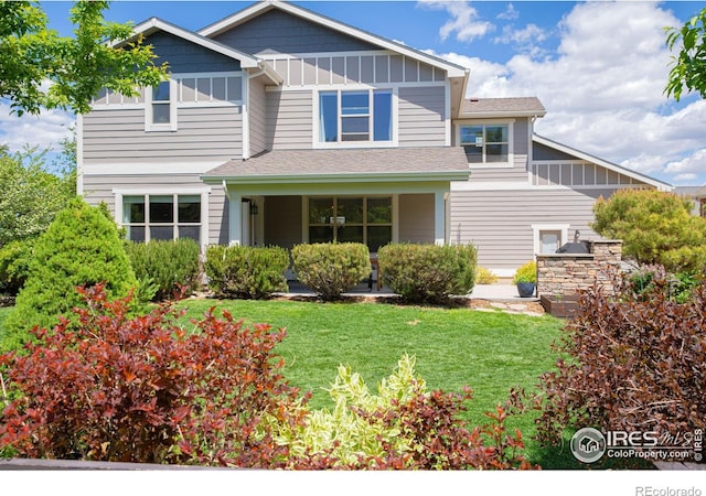 6523 Spanish Bay Dr, Windsor, CO 80550 - view of front facade with covered porch, a front lawn, board and batten siding, and roof with shingles