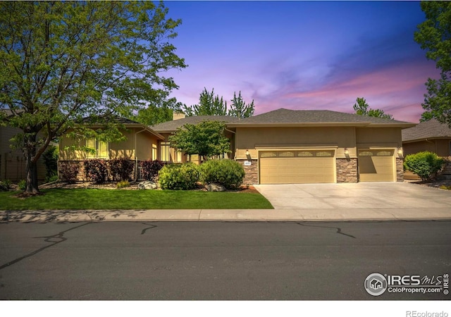 6535 Half Moon Bay Dr, Windsor, CO 80550 - view of front of property featuring stone siding, driveway, a garage, stucco siding, and a front yard