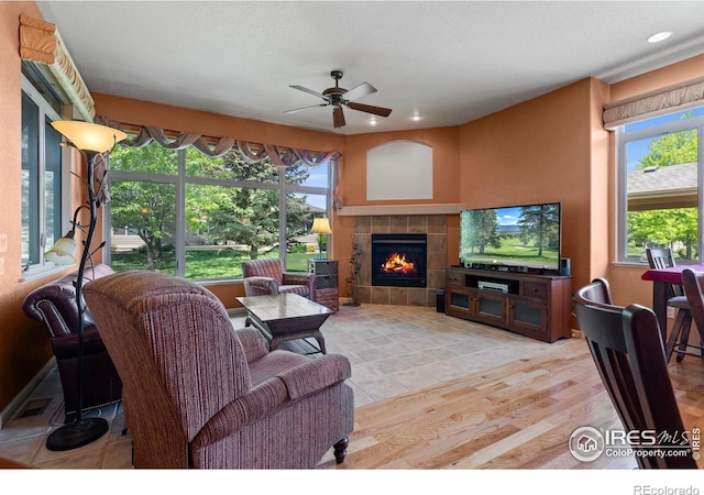 6535 Half Moon Bay Dr, Windsor, CO 80550 - living area with a ceiling fan, a tiled fireplace, light wood finished floors, and recessed lighting