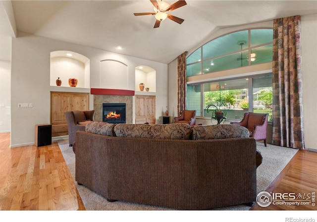 6535 Half Moon Bay Dr, Windsor, CO 80550 - living room featuring a tile fireplace, ceiling fan, wood finished floors, lofted ceiling, and recessed lighting