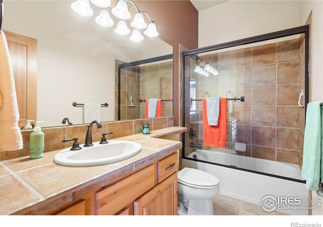 6535 Half Moon Bay Dr, Windsor, CO 80550 - full bathroom featuring vanity, toilet, enclosed tub / shower combo, and tile patterned flooring