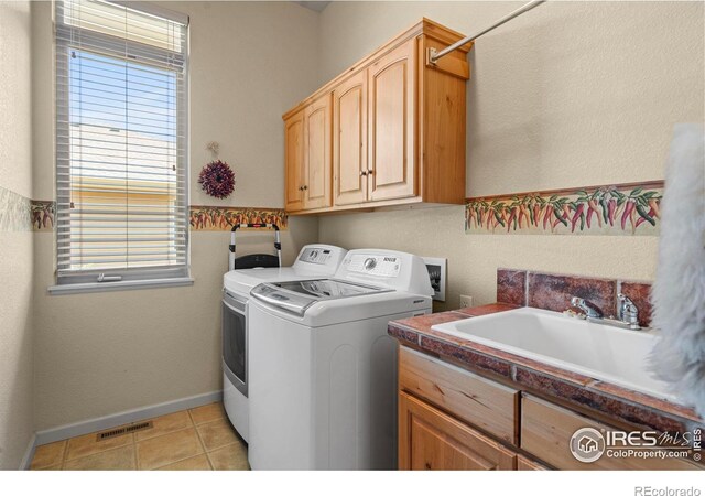 6535 Half Moon Bay Dr, Windsor, CO 80550 - washroom with washer and dryer, cabinet space, light tile patterned floors, and baseboards