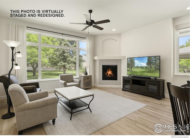 6535 Half Moon Bay Dr, Windsor, CO 80550 - living area with ceiling fan, wood finished floors, a tiled fireplace, and recessed lighting