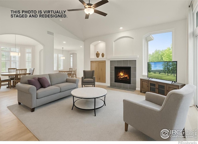 6535 Half Moon Bay Dr, Windsor, CO 80550 - living area featuring ceiling fan, a fireplace, recessed lighting, arched walkways, and lofted ceiling
