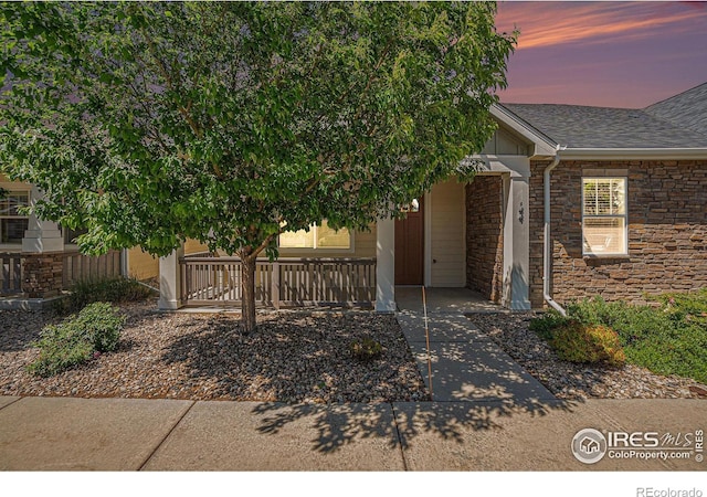 4751 Pleasant Oak Dr Unit B44, Fort Collins, CO 80525 - view of front facade with covered porch, stone siding, and roof with shingles
