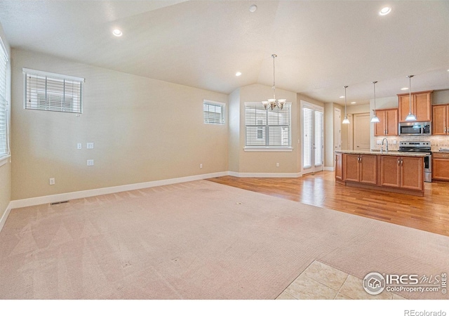 4751 Pleasant Oak Dr Unit B44, Fort Collins, CO 80525 - kitchen with appliances with stainless steel finishes, light carpet, a sink, a chandelier, and recessed lighting