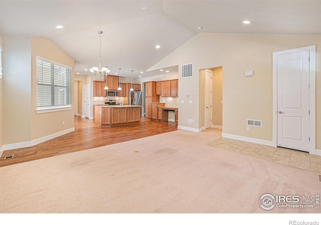 4751 Pleasant Oak Dr Unit B44, Fort Collins, CO 80525 - kitchen with light carpet, open floor plan, appliances with stainless steel finishes, a chandelier, and vaulted ceiling