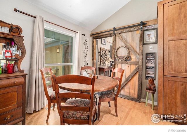 3412 Erving Ct, Berthoud, CO 80513 - dining space featuring vaulted ceiling, light wood-style floors, and a barn door