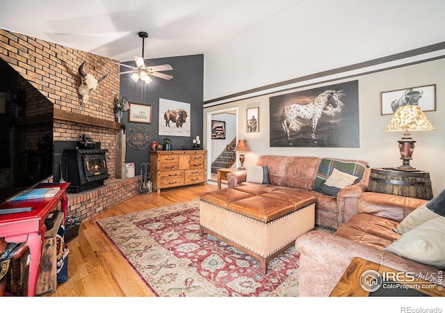 3412 Erving Ct, Berthoud, CO 80513 - living room featuring a wood stove, wood finished floors, ceiling fan, high vaulted ceiling, and stairway