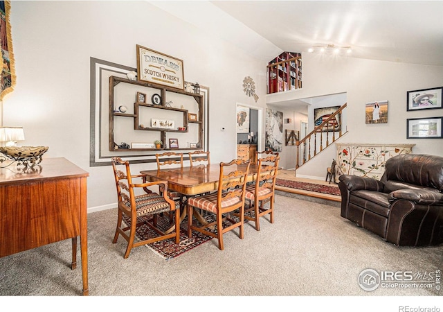 3412 Erving Ct, Berthoud, CO 80513 - dining area with carpet floors, stairs, baseboards, and high vaulted ceiling