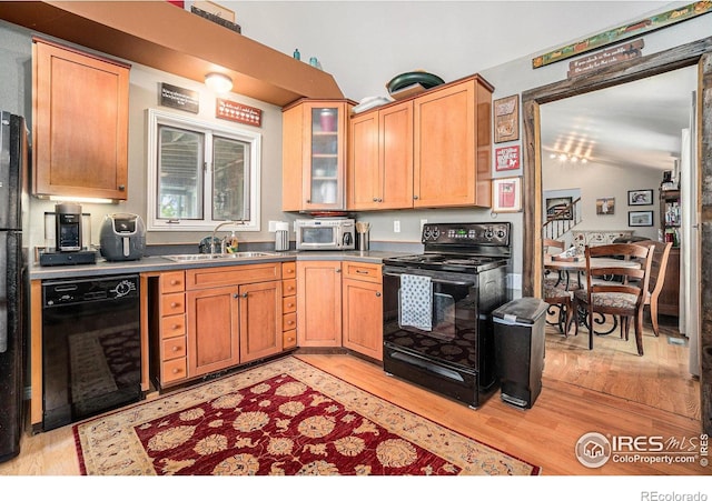 3412 Erving Ct, Berthoud, CO 80513 - kitchen featuring black appliances, a sink, light wood-style floors, and glass insert cabinets