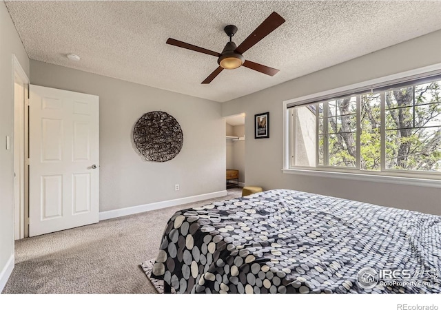 855 W Moorhead Cir Unit C, Boulder, CO 80305 - bedroom featuring carpet, a textured ceiling, baseboards, a ceiling fan, and a walk in closet