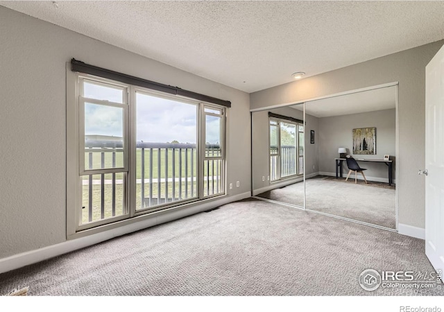 855 W Moorhead Cir Unit C, Boulder, CO 80305 - unfurnished bedroom featuring carpet flooring, access to outside, a textured ceiling, baseboards, and a closet