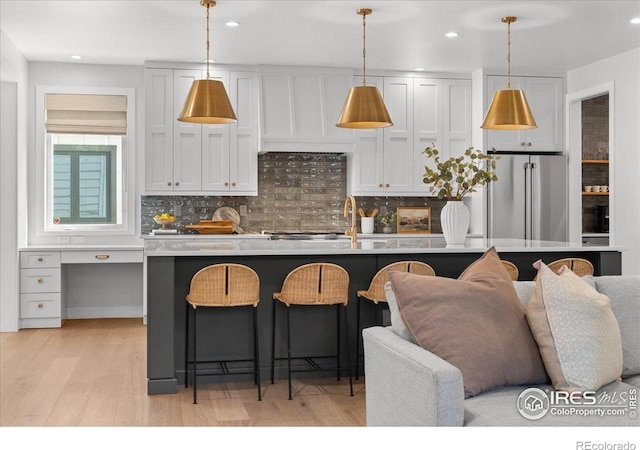 3256 S Corona St, Englewood, CO 80113 - kitchen with freestanding refrigerator, light wood-type flooring, decorative backsplash, a breakfast bar area, and recessed lighting
