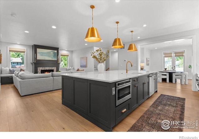 3256 S Corona St, Englewood, CO 80113 - kitchen with stainless steel microwave, light wood-type flooring, plenty of natural light, light countertops, and recessed lighting