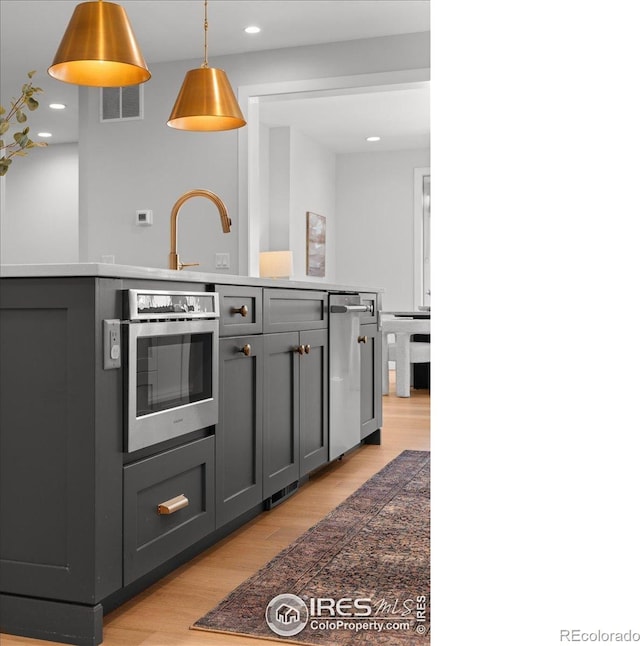 3256 S Corona St, Englewood, CO 80113 - kitchen featuring gray cabinetry, light wood-style floors, recessed lighting, hanging light fixtures, and appliances with stainless steel finishes