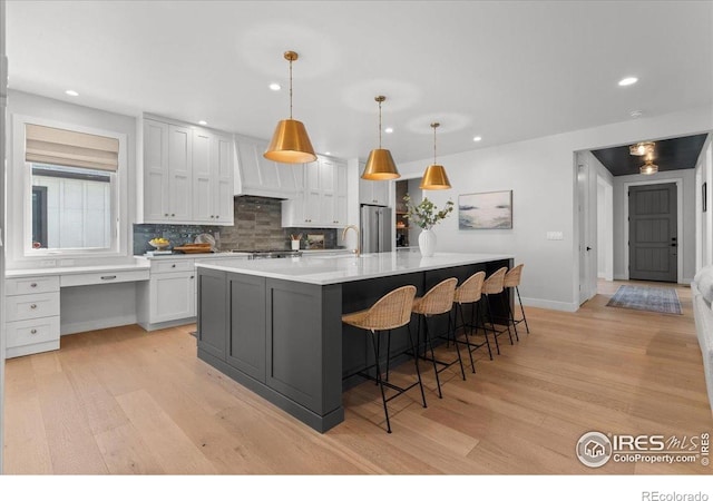 3256 S Corona St, Englewood, CO 80113 - kitchen with light wood-style flooring, recessed lighting, tasteful backsplash, custom exhaust hood, and high quality fridge