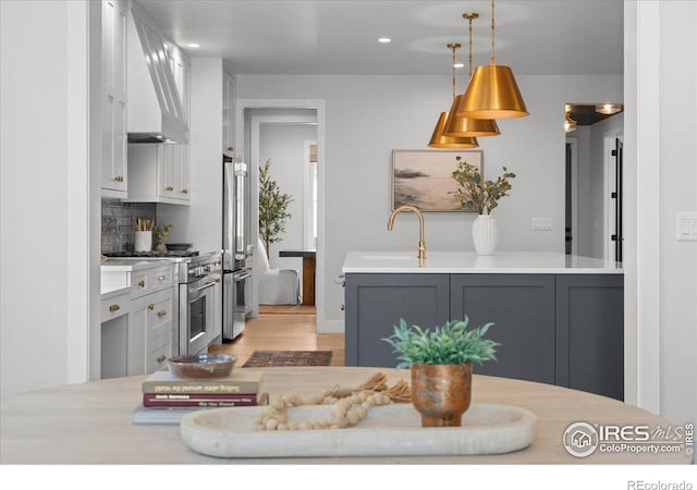 3256 S Corona St, Englewood, CO 80113 - kitchen with stainless steel appliances, custom exhaust hood, light countertops, and recessed lighting